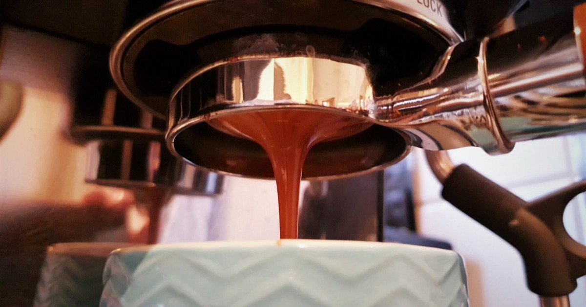 Coffee being brewed by the machine flowing through portafilter